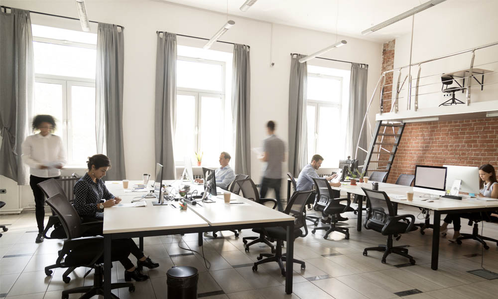 The Advantages of Self Funding - Group of Coworkers In An Industrial Decorated Office Working Separately